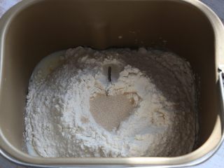 2、汉堡,将鸡蛋、牛奶、先倒入面包机，糖、盐对角线放置，再放入面粉，面粉中挖个洞，放入酵母。