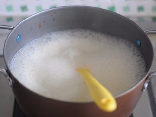 4、#不一样的泡芙#卡仕达焦糖泡芙塔,牛奶加入剩下的白糖放在火上,扑哧扑哧沸腾起来后,立刻将五分之一的量加入蛋黄液里,剩余的牛奶用极小的火保温