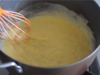 5、#不一样的泡芙#卡仕达焦糖泡芙塔,变柔滑后到回加入牛奶的锅里开大火加热,用手动打蛋器充分搅拌使它加热,
