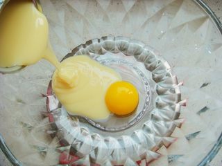 1、＃甜味＃暖暖熊香肠烧果子,盆里打入一个蛋黄倒入炼乳。