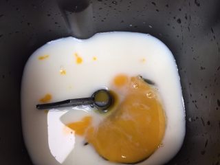 2、一发也能做出超级柔软的土司,面包机，放入搅拌器，在面包桶里，加入鸡蛋和牛奶水；