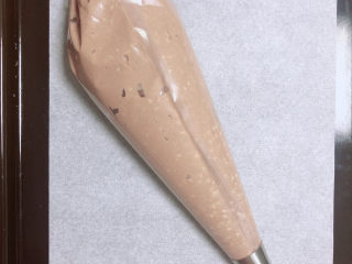 12、芝麻薄脆饼干,将所有面糊放入裱花袋中。烤盘中放一张油纸。预热烤箱，180度预热5分钟。