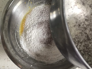 5、巧克力纸杯蛋糕????,再分两次筛入低筋面粉和可可粉画“z”字搅拌至无颗粒