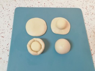 4、枣泥核桃卷,取一个油皮面团压扁，放入一个油酥面团 ，收口捏紧向下摆放，盖上保鲜膜。