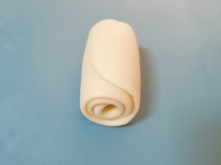 7、枣泥核桃卷,卷起，收口向下摆放，盖上保鲜膜松弛15分钟左右。