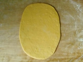 12、毛毛虫南瓜面包,取其中一份，擀开成椭圆形面饼