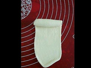 6、纯牛奶小吐司,取一个剂子擀成长条状,由上至下卷起