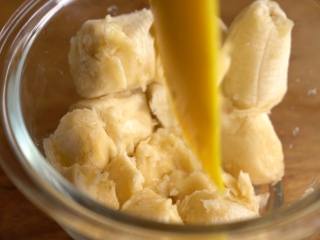 5、湿润蓬松【香蕉椰蓉蛋糕】好吃的不得了,香蕉倒入容器中，按压成香蕉泥，倒入蛋液中