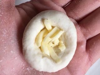 9、爆浆土豆芝士球,取一个小剂子揉成球，用大拇指按压出一个小窝，填入芝士。