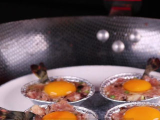 10、往虾里打入一颗蛋——虾扯蛋,接着将做好了的虾扯蛋装入盘中下锅隔水蒸。