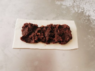 7、红豆派,铺上一层红豆沙，四周边缘刷一层水。