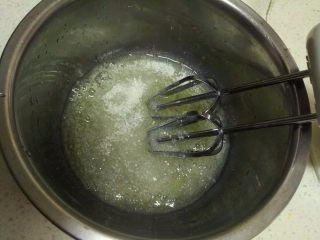 6、酸 奶 小 蛋 糕 ,蛋白中加入3滴柠檬汁,用电动打蛋器搅拌。打蛋器低速将蛋白打出鱼泡眼时加第一次糖。