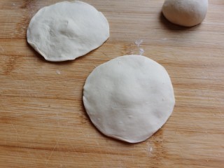 8、糖火烧,取一份揉圆，擀成四周薄中间厚的圆形面皮。