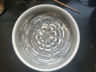 17、斑马纹戚风蛋糕,用一根筷子从外向中心划线,拉出漂亮花纹。也可以不拉花。然后放进预热好的烤箱,上下火,140度。烤50分钟。每个烤箱温度不一样,根据自己的烤箱性能习惯调整时间。