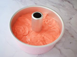 14、八寸中空红丝绒戚风蛋糕,把拌匀的蛋糕糊倒入学厨8寸的中空模具中，端起模具的两端，指拇按住中空柱上空，轻轻震几下，震出大气泡