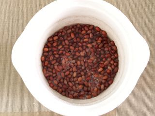 7、适合三高人士的无糖无油红豆沙,开始煮红豆吧,我用的是电煮锅,红豆倒入锅里,水量刚刚好浸过红豆即可,如图可见,不要加太多的水量,因为已经泡过一夜的红豆,不会再吃很多水分了