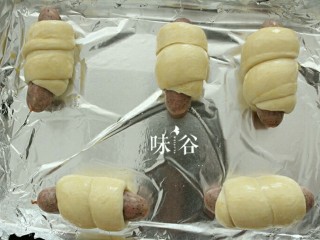 11、黑椒火腿肠面包,放在烤盘里，放入烤箱里再发酵到一倍大。