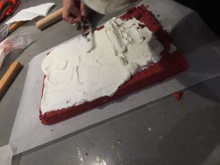 16、红丝绒蛋糕卷,蛋糕卷稍晾凉后用抹刀把打发好的奶油铺在蛋糕卷上，四边薄中间厚