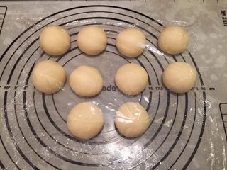 3、危险与美味并存一一德国碱水包,将面团平均分成10小份，盖上保鲜膜静置20分钟