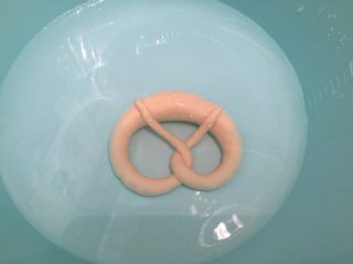 9、危险与美味并存一一德国碱水包,准备一个塑料盆，先倒入40度温水，再倒入烘焙碱，带上塑胶手套（一定要），将普雷结放入碱水内，泡10－20秒后翻面再泡10－20秒，捞出沥干水分