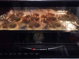 12、危险与美味并存一一德国碱水包,将普雷结放入烤箱，朝烤箱喷洒一些蒸汽，上下火15－20分钟（变成棕红色）