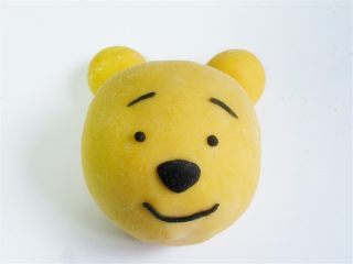 15、维尼豆沙馒头,把另外两个小的放在上面做耳朵，把黑可可粉面团取少许拧成条做表情鼻子、眼睛嘴巴眉毛，注意眉毛和嘴巴要拧细一些才好看