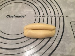 8、迷你热狗包,擀成牛舌状，上下向中间卷，收口捏紧搓成椭圆形