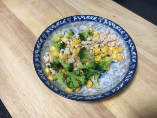 7、吐司披萨盏,将小朵西兰花、玉米粒、鸡肉火腿碎放在容器里，放入少许的盐和少许的黑胡椒碎，搅拌均匀备用。