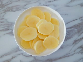3、凤尾虾球,切成土豆片放入盘中，上锅蒸熟