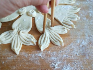 10、新文美食  小鱼蒸饼,在用筷子夹紧鱼尾。