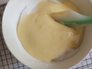 10、平底锅舒芙蕾,再把它倒回蛋白糊中，继续用刮刀翻拌均匀