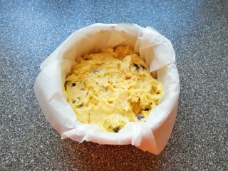 13、香橙巧克力妙芙蛋糕,6寸戚风模具里面垫上油纸，放入拌好的蛋糕糊，用刮刀抹平。