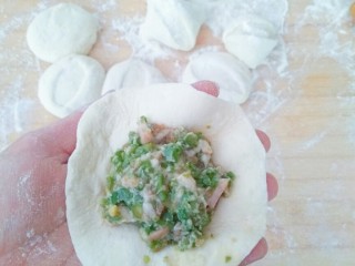 9、早餐生煎包,取一个包子皮中间放馅。