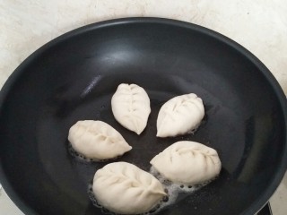 12、早餐生煎包,煎锅放2汤匙花生油,摆放包子,中小火烙至底部金黄色。