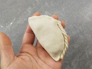 8、韭菜盒子,对叠呈半圆形，再捏出花边，不捏也行，把边捏紧就行