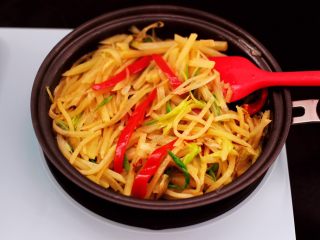 9、土豆丝红椒煎春卷,大火翻炒红椒变软即可关火,炒好的土豆丝盛出备用。