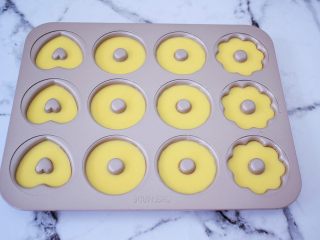 7、巧克力蛋糕甜甜圈,挤入学厨12连模甜甜圈的模具，7-8分满即可，提起模具震一震，震出大气泡