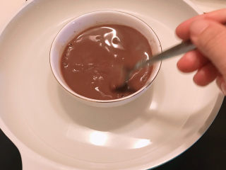 11、巧克力慕斯蛋糕,用叉子搅拌均匀，让吉利丁片充分融化。