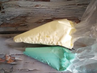 13、蝶豆花麦芬杯,一半要原色，一半调入蓝色色素。然后把两种颜色装入一个裱花袋就可以挤出双色的花朵了。