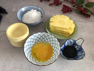 1、酥甜菠萝酥,准备好所有材料，菠萝，鸡蛋黄，白糖，蛋挞皮，黑芝麻。