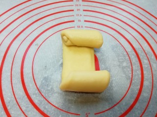 9、甜味面包卷, 继续压扁擀开成牛舌状，从两头往中间卷起。
