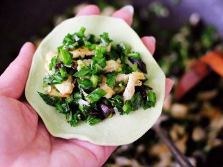 15、鹅蛋韭菜翠玉盒子,把擀好的面皮里放入适量搅拌好的馅料。