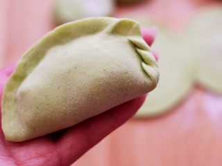 16、鹅蛋韭菜翠玉盒子,把放入馅料的面皮用手把面皮的边边捏紧后，再从面皮的一边开始捏，反复压一下捏一下。