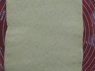 8、牛角面包,取出排气盖保鲜膜松弛15分钟后擀成大片