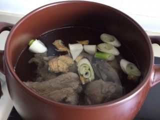 10、筒骨海带汤,大骨头和咸肉在流动水下冲洗干净放入砂锅里，一次性注入足量的水，放姜块、葱段，盖上锅盖开中大火煮开转小火煮半小时。