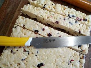 14、牛轧糖沙琪玛,晾凉后倒出来，先切条再切块。我用的 学厨的日本钢面包刀切的。晚上切的块，厨房光线暗，拍照有些失色。