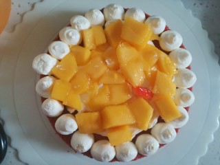 17、红丝绒草莓????裸蛋糕,蛋糕盘子先抹一点奶油，放一片蛋糕坯，周围挤入奶油，中间先抹奶油，再放芒果丁