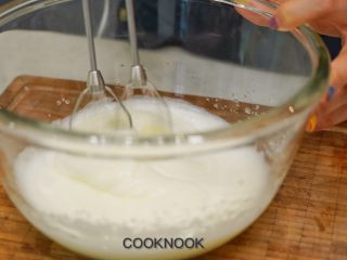 6、北海道芝士奶油杯子蛋糕,倒入一半的白砂糖, 继续用电动打蛋器打发ㄧ分钟, 倒入剩下的白砂糖, 打发蛋白到挺