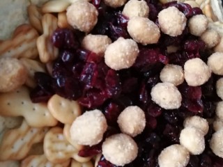 4、雪花酥,棉花糖融化后，快速加入蔓越莓、小饼干和花生米。