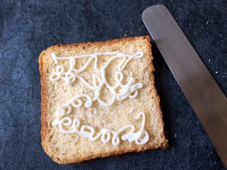 4、早餐+鸡蛋芝士土司面包,在没压过的土司上挤上沙拉酱,尽量多挤点,用工具将沙拉酱抹平